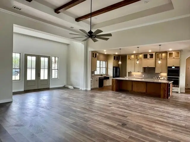Open-plan Central Texas home with new wide-plank flooring running to the kitchen island